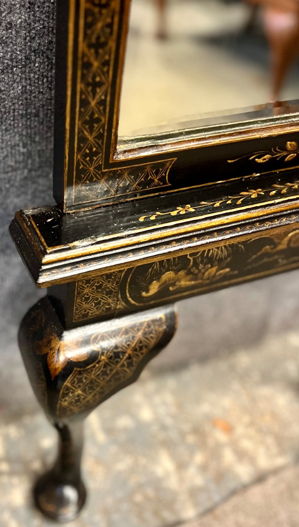 A tall, narrow black lacquered hall mirror decorated with gilded Chinoiserie pagodas and figures, featuring an arched top and front cabriole legs. View VII