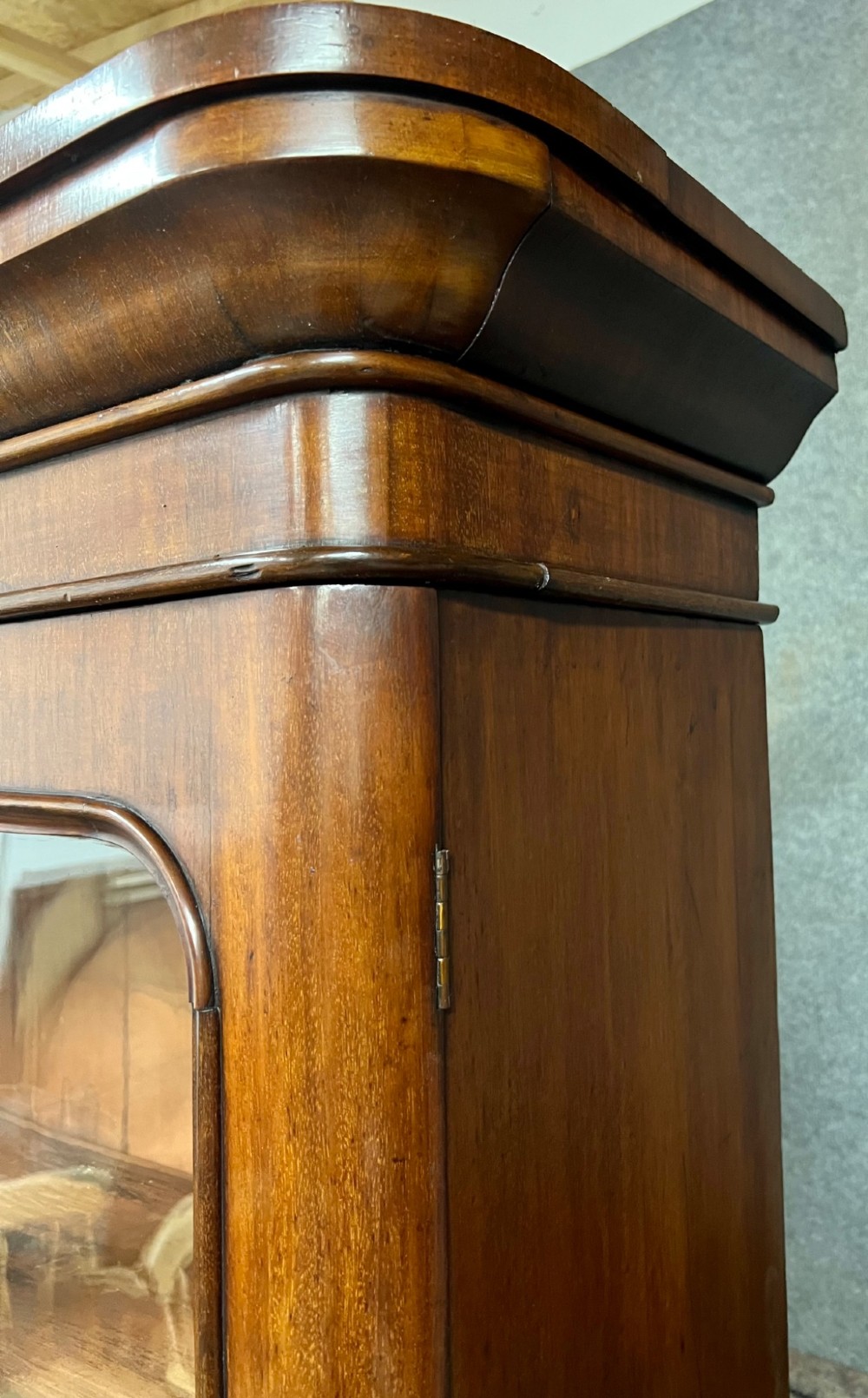 A two-door Victorian mahogany bookcase featuring an upper glazed cabinet with rounded corner panes and a lower enclosed wooden cupboard. View IV