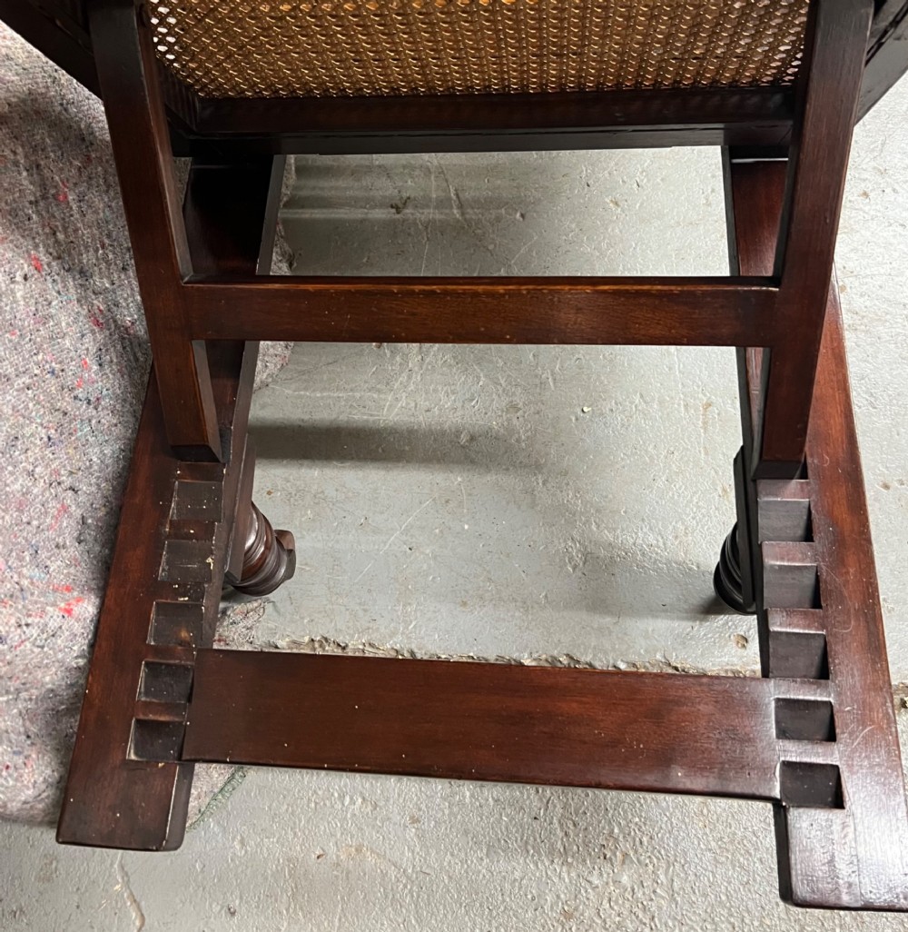An antique mahogany campaign bed featuring three hinged folding sections with woven cane panelling and a dark timber frame. View IV