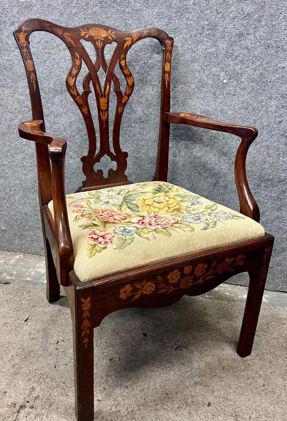 An antique mahogany armchair featuring floral marquetry wood inlays throughout the frame and splat, fitted with a floral needlepoint upholstered seat. View IV