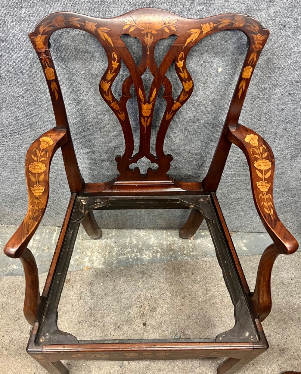 An antique mahogany armchair featuring floral marquetry wood inlays throughout the frame and splat, fitted with a floral needlepoint upholstered seat. View VI