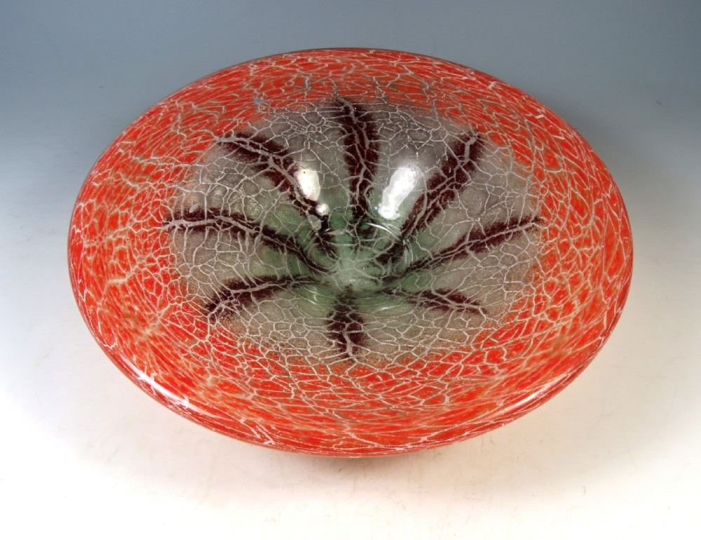 A circular Art Deco WMF Ikora glass bowl featuring a bright red crackle-effect rim and a clear centre with dark starburst inclusions.