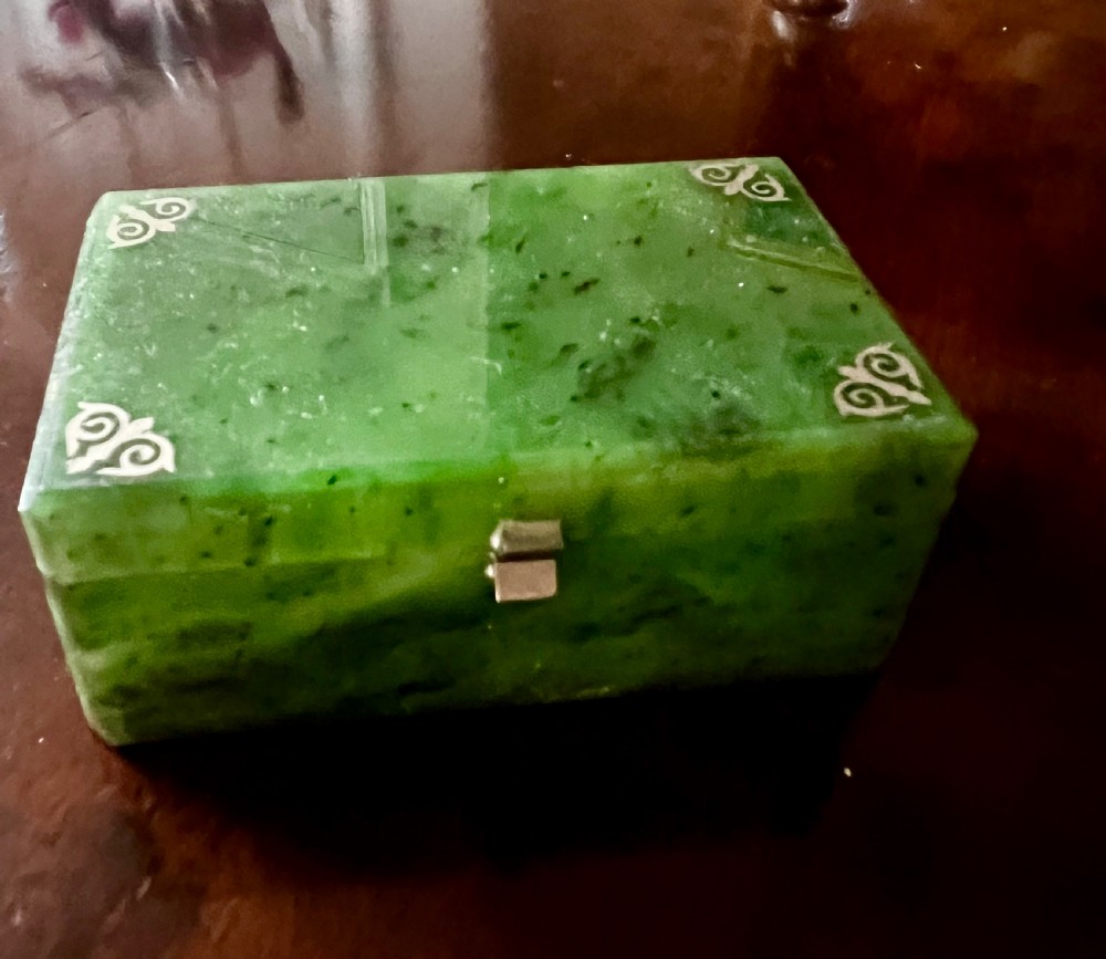 A rectangular polished green stone trinket box featuring metal corner mounts and a metal latch on the front.