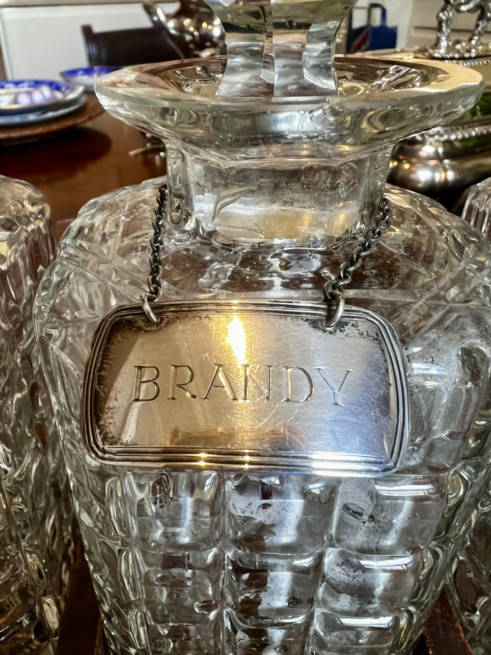 An antique Edwardian oak tantalus housing three cut-glass decanters with matching silver labels, fitted with a brass handle and locking mechanism. View VIII