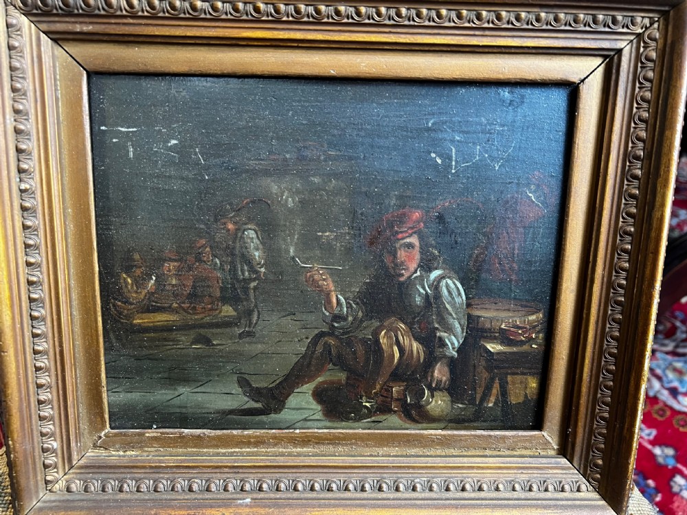 A Victorian oil painting on board depicting a seated man smoking a pipe in a tavern setting, framed in molded gilt wood.