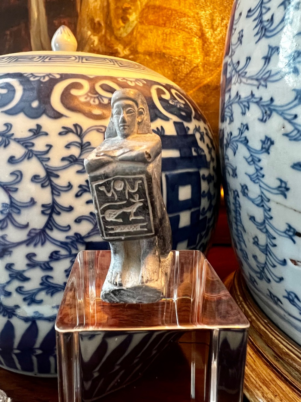 Four carved grey stone Egyptian scarabs and deity figurines displayed individually on clear acrylic block stands. View II