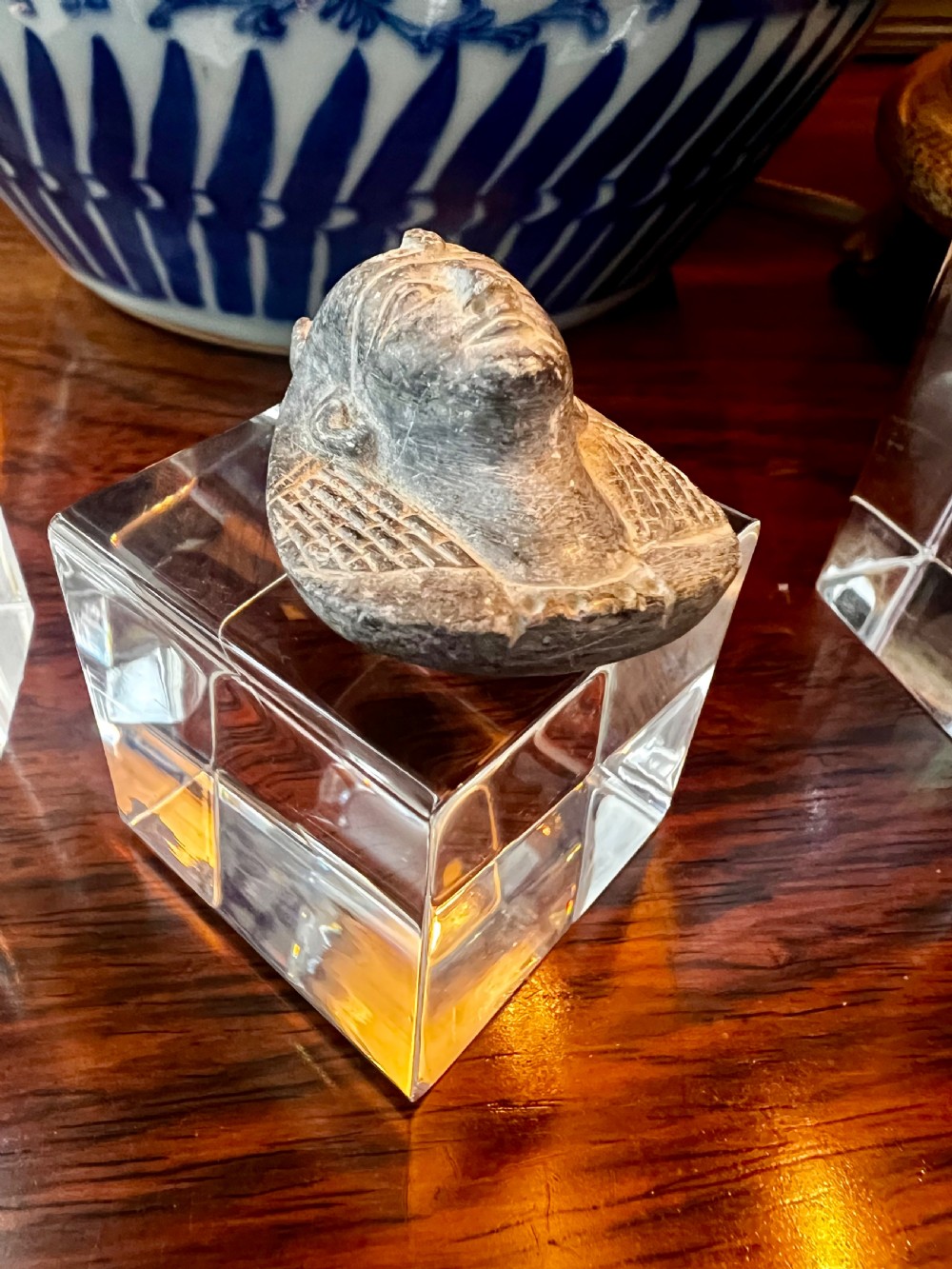 Four carved grey stone Egyptian scarabs and deity figurines displayed individually on clear acrylic block stands. View VI