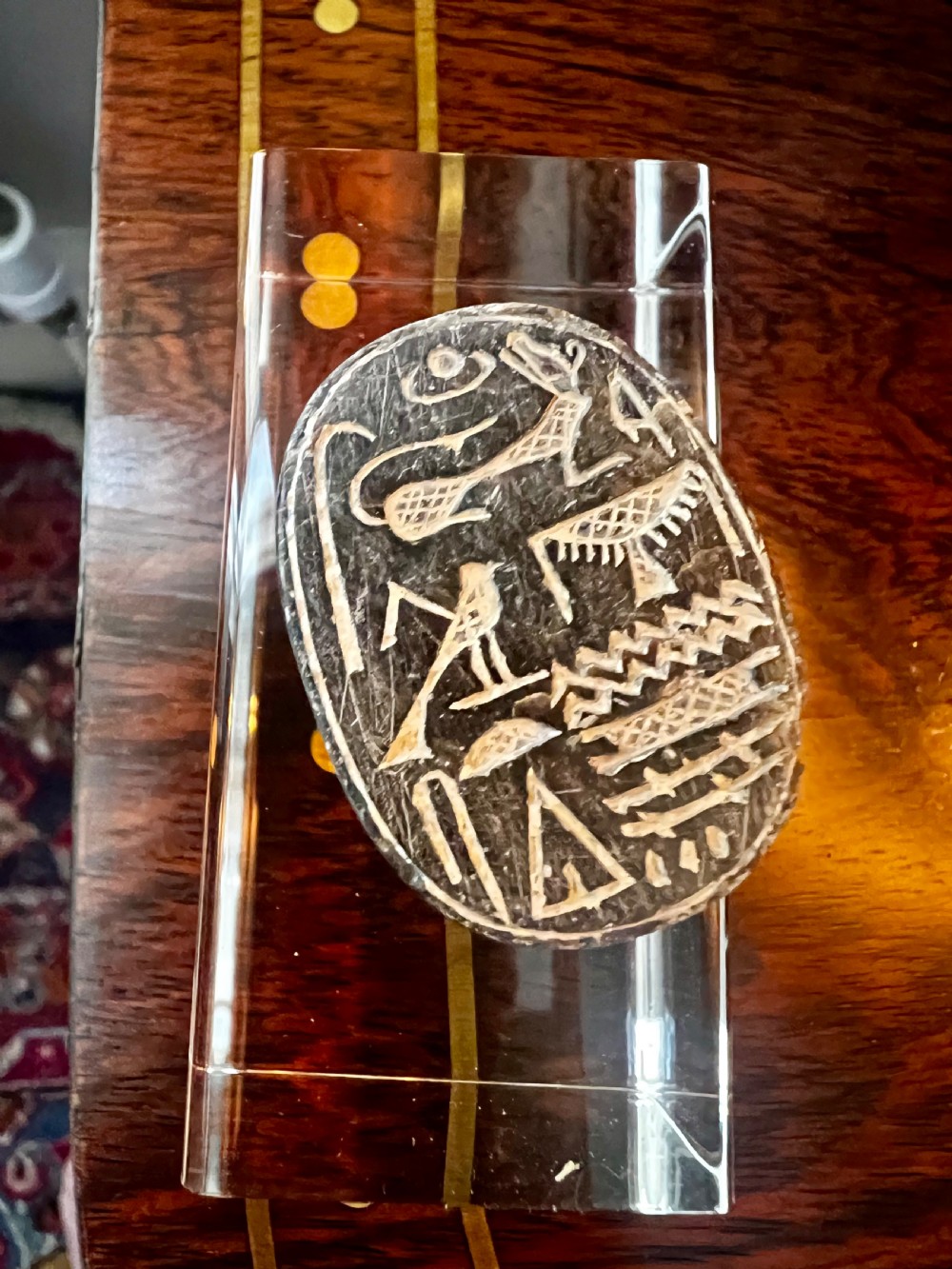 Four carved grey stone Egyptian scarabs and deity figurines displayed individually on clear acrylic block stands. View XI