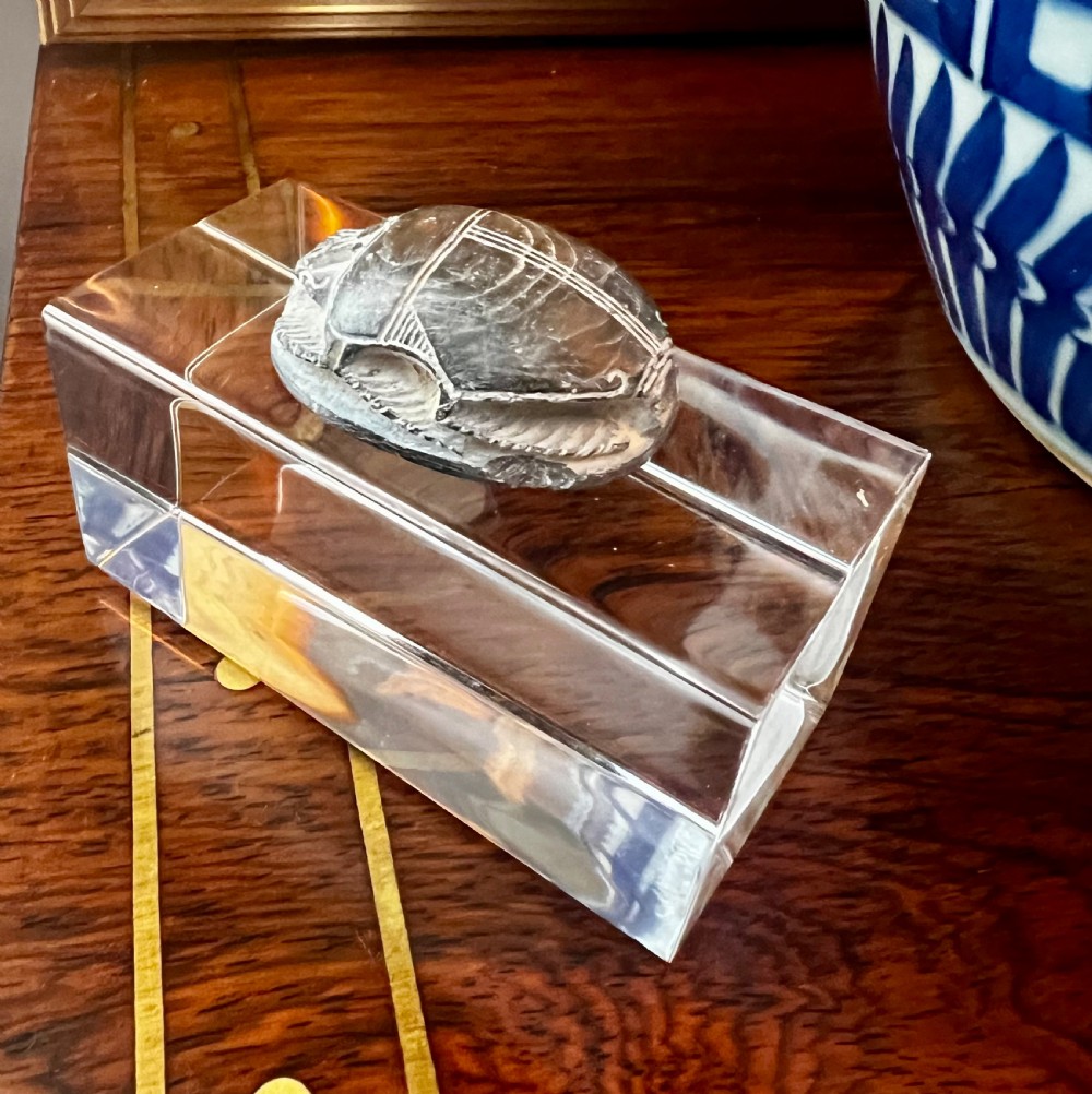 Four carved grey stone Egyptian scarabs and deity figurines displayed individually on clear acrylic block stands. View XII