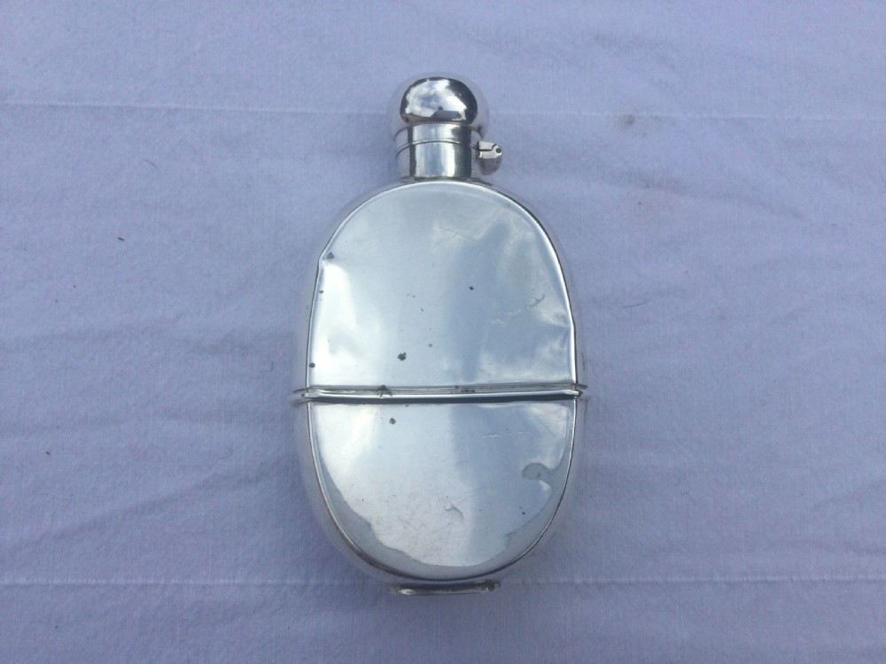A curved silver hip flask featuring an engraved signature dated 1922, hallmarked collar, and a hinged domed cap. View II