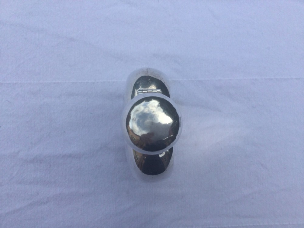 A curved silver hip flask featuring an engraved signature dated 1922, hallmarked collar, and a hinged domed cap. View IV