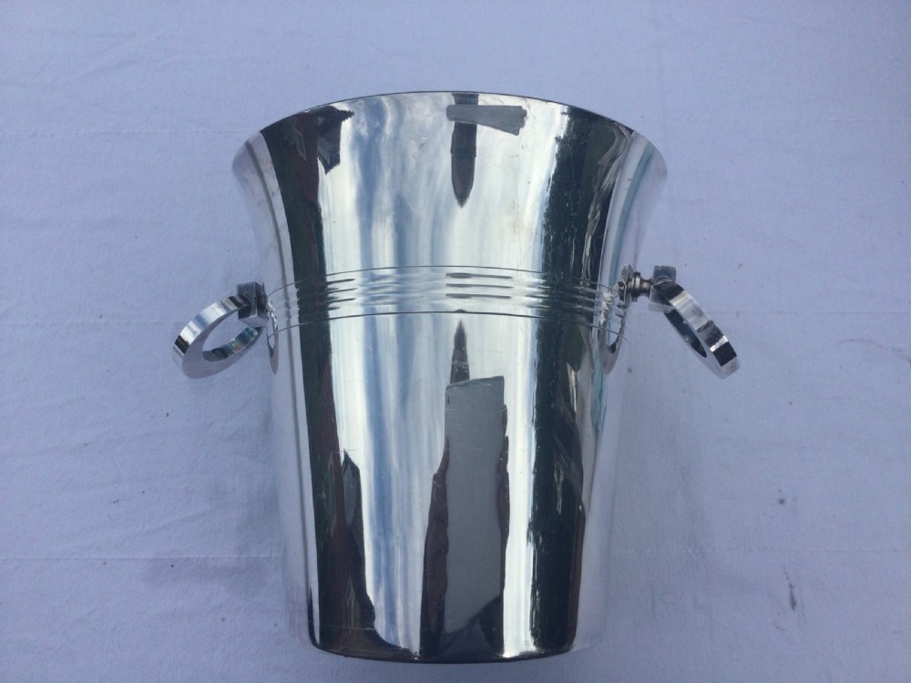 A polished silver-plated champagne bucket featuring reeded horizontal band decoration and ring side handles.