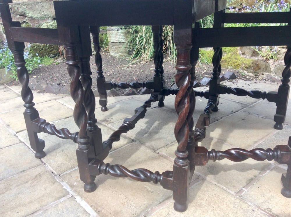 An antique dark oak oval gateleg table featuring barley twist turned legs, stretchers, and folding drop leaves. View III
