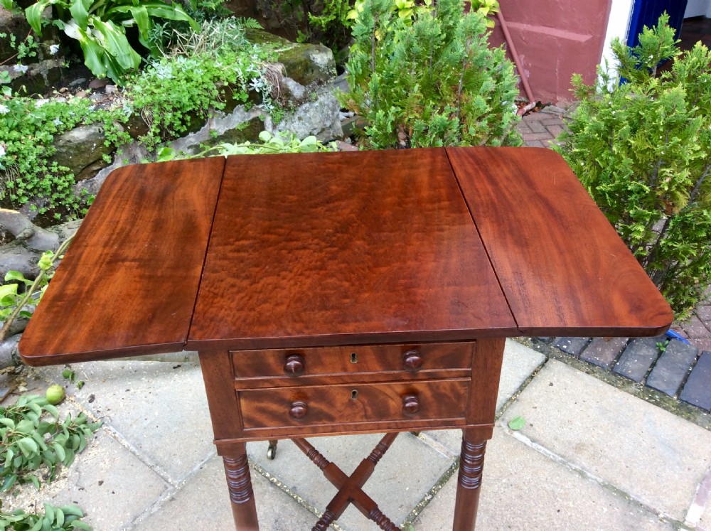 A Regency mahogany Pembroke table featuring two drawers, drop-leaf sides, turned reeded legs, a cross-stretcher, and brass castors. View VII