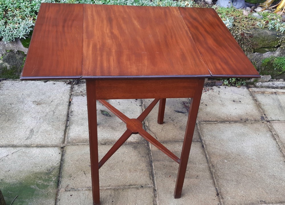 A small mahogany Pembroke side table featuring two drop leaves, a single drawer with a brass handle, square tapered legs, and an X-frame stretcher. View V