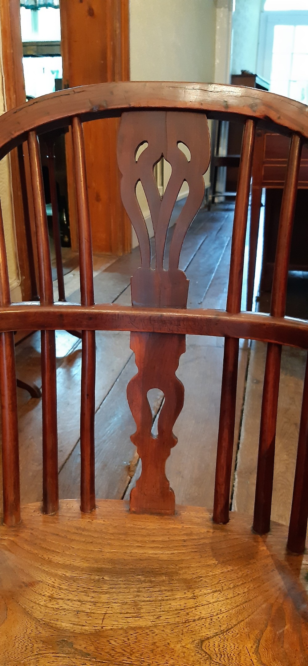An antique yew wood childs Windsor armchair featuring a hoop back with central pierced splat, spindled backrest, shaped armrests, turned legs, and a carved seat. View IV