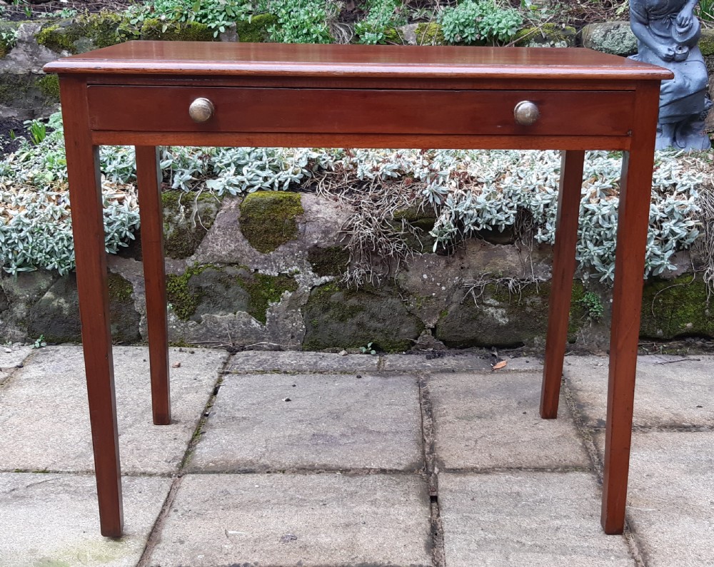 A Georgian mahogany side table featuring a rectangular top, a single wide drawer with two turned wooden knobs, and four square tapered legs. View III
