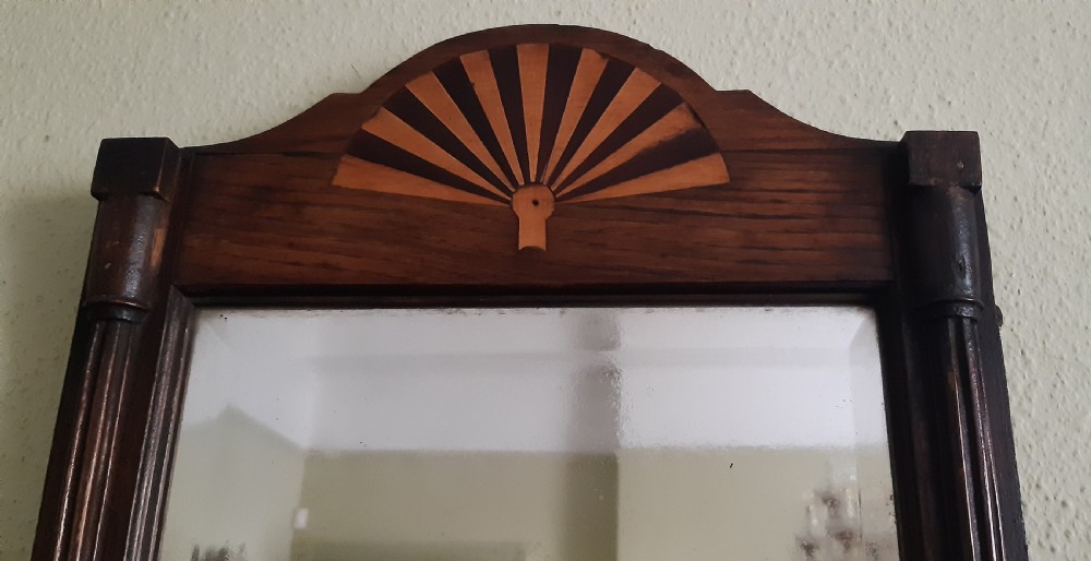 A tall dark oak wall mirror featuring fan marquetry inlay on the arched cresting and reeded side pilasters. View III