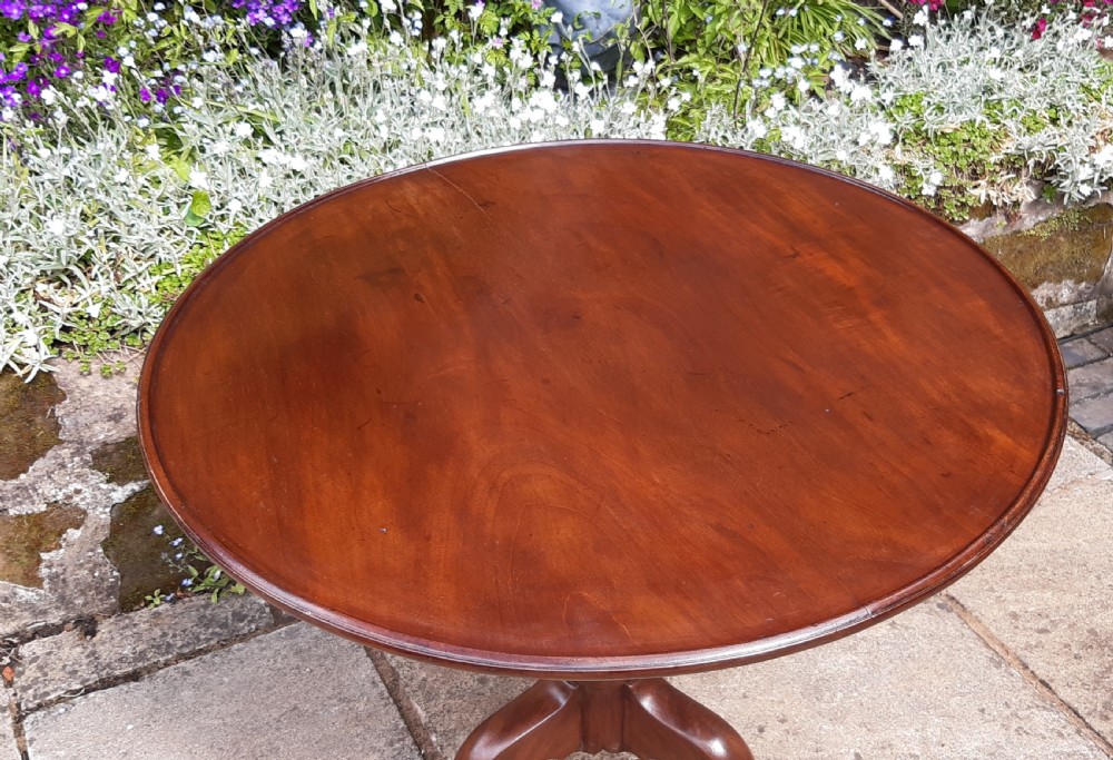 A Georgian circular mahogany tripod table featuring a turned central pedestal and three cabriole legs. View II