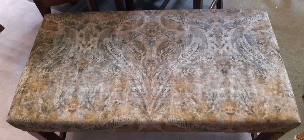 An upholstered rectangular mahogany stool featuring patterned brown fabric with stud detailing and straight legs joined by an H-stretcher. View II