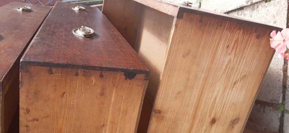 A Georgian dark oak chest of drawers featuring two short drawers over three long drawers with oval brass handles and bracket feet. View V