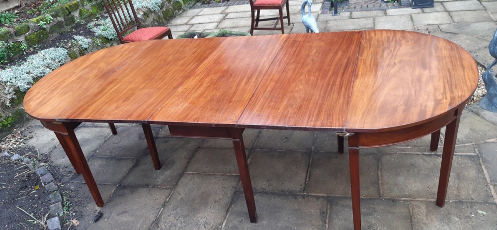 A large Georgian mahogany extending dining table featuring modular leaves and square tapered legs. View II