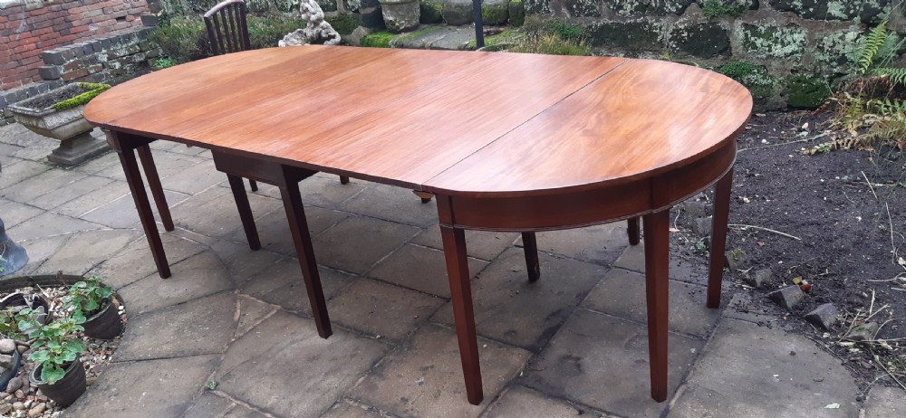 A large Georgian mahogany extending dining table featuring modular leaves and square tapered legs. View III