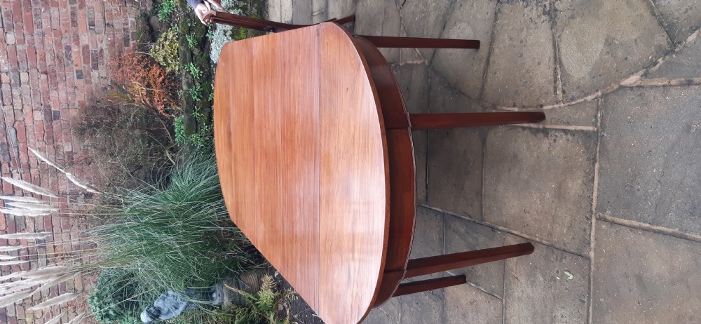 A large Georgian mahogany extending dining table featuring modular leaves and square tapered legs. View V
