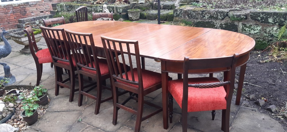 A large Georgian mahogany extending dining table featuring modular leaves and square tapered legs. View VI