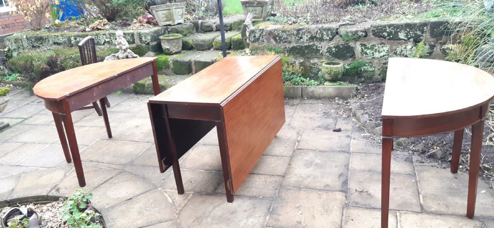 A large Georgian mahogany extending dining table featuring modular leaves and square tapered legs. View IX