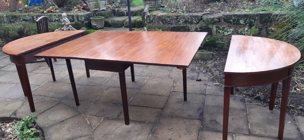 A large Georgian mahogany extending dining table featuring modular leaves and square tapered legs. View X
