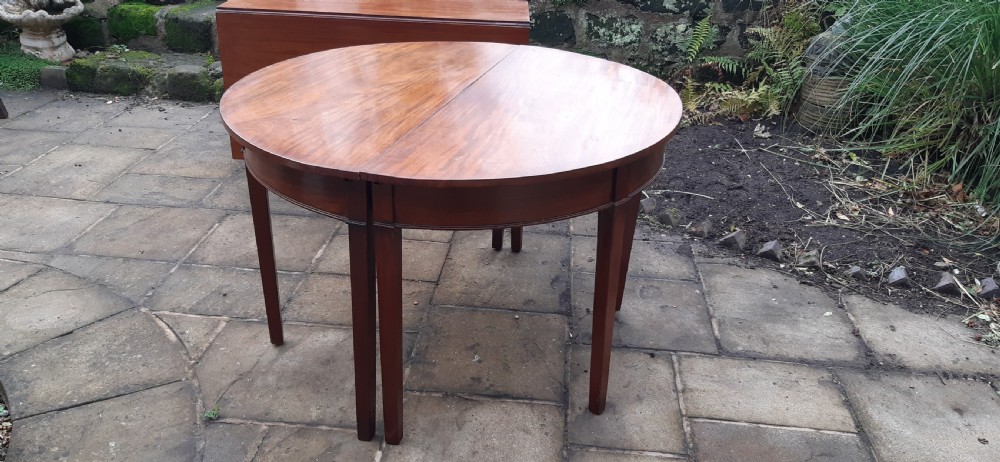 A large Georgian mahogany extending dining table featuring modular leaves and square tapered legs. View XI