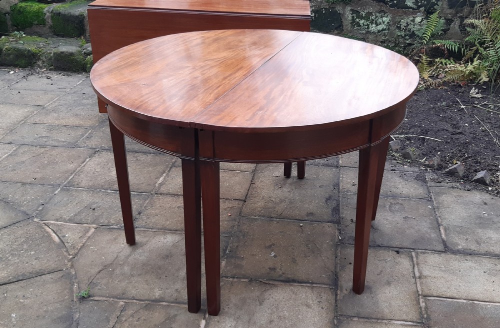A large Georgian mahogany extending dining table featuring modular leaves and square tapered legs. View XV
