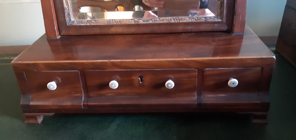 A Georgian mahogany toilet mirror featuring an adjustable rectangular glass frame set between upright posts above a wooden base with three drawers. View II