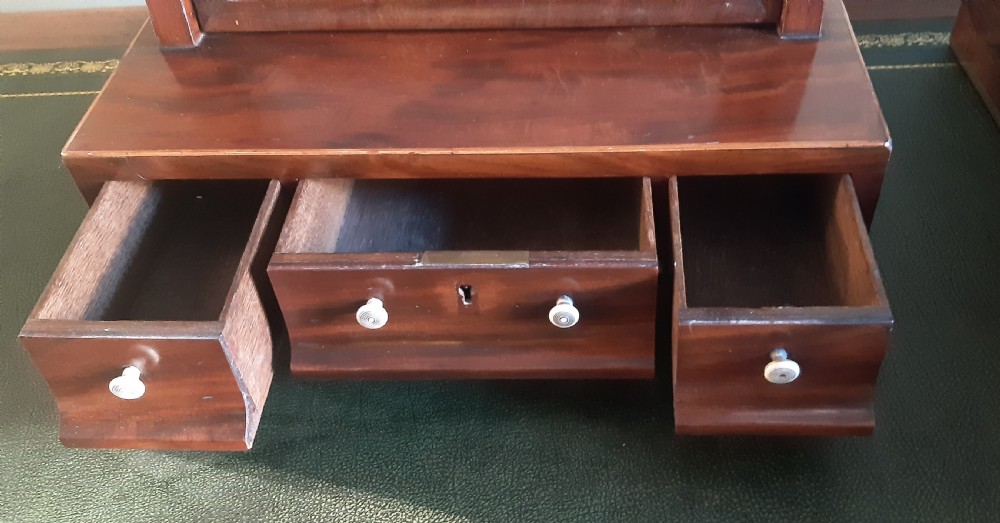 A Georgian mahogany toilet mirror featuring an adjustable rectangular glass frame set between upright posts above a wooden base with three drawers. View III