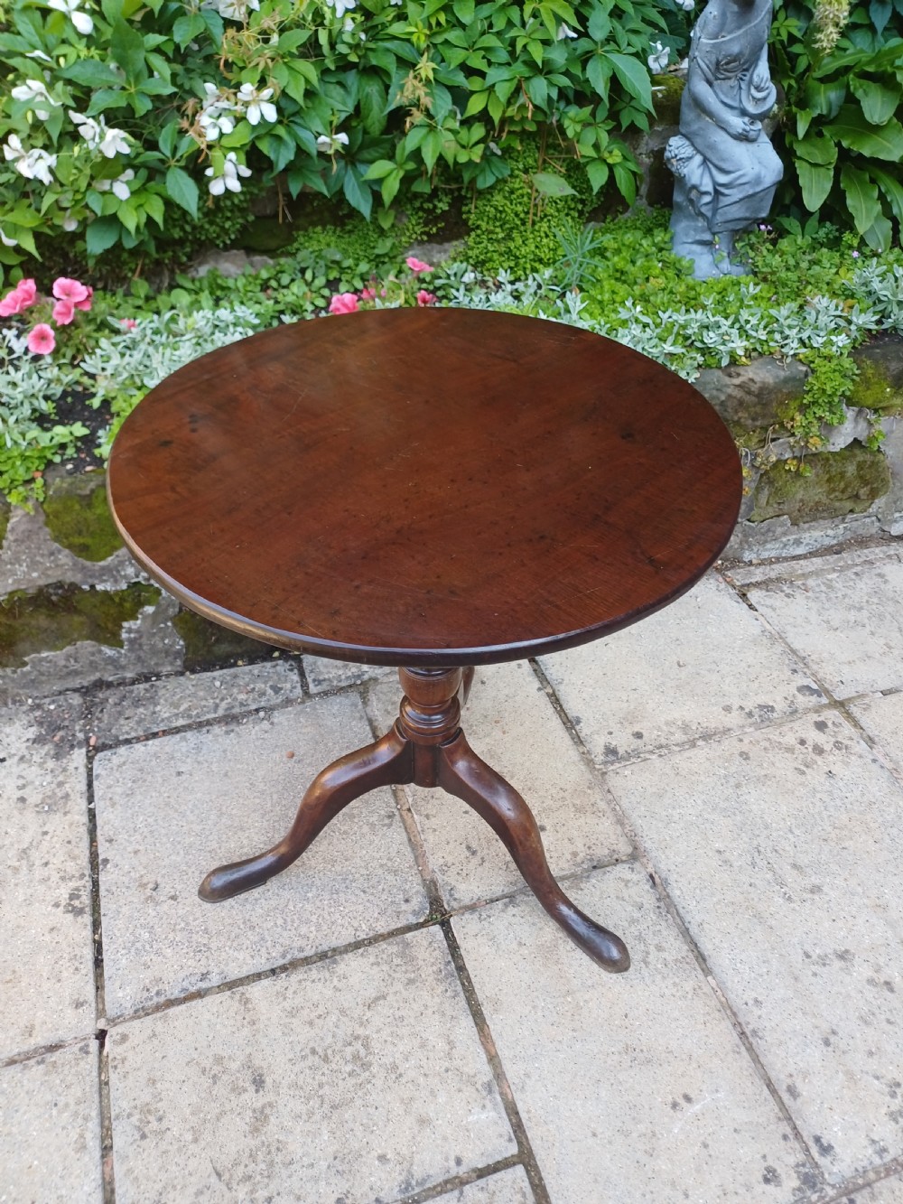 A Georgian mahogany tripod table featuring a circular top, a turned central baluster pedestal, and three splayed cabriole legs. View II