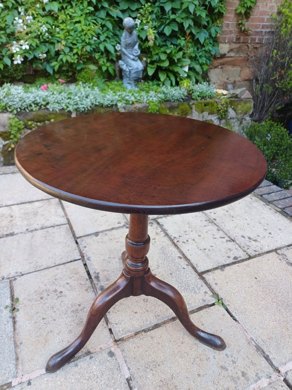 A Georgian mahogany tripod table featuring a circular top, a turned central baluster pedestal, and three splayed cabriole legs. View V