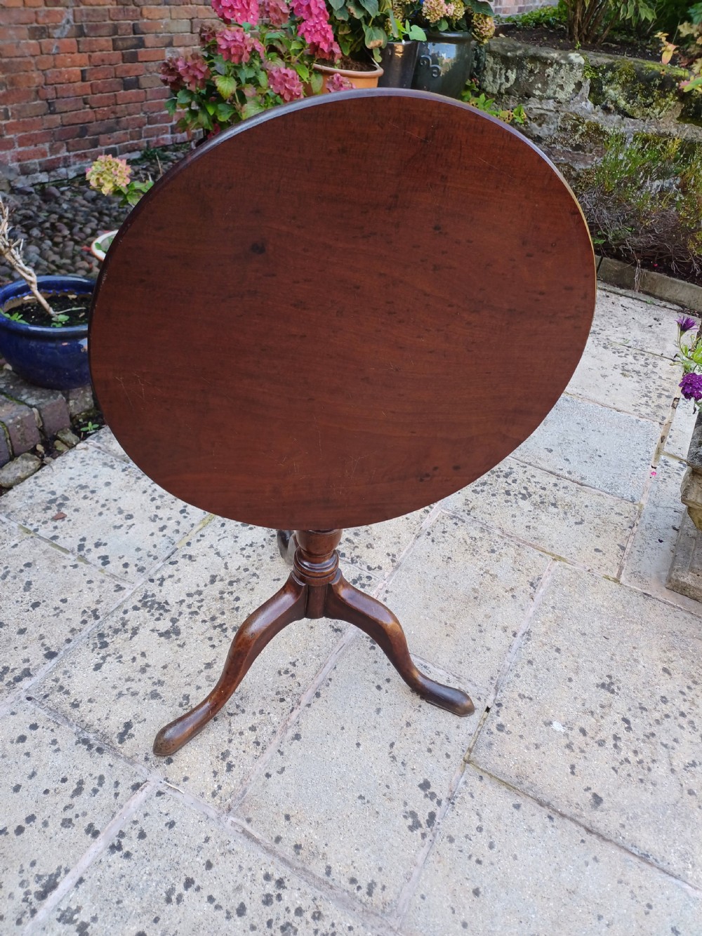 A Georgian mahogany tripod table featuring a circular top, a turned central baluster pedestal, and three splayed cabriole legs. View VI