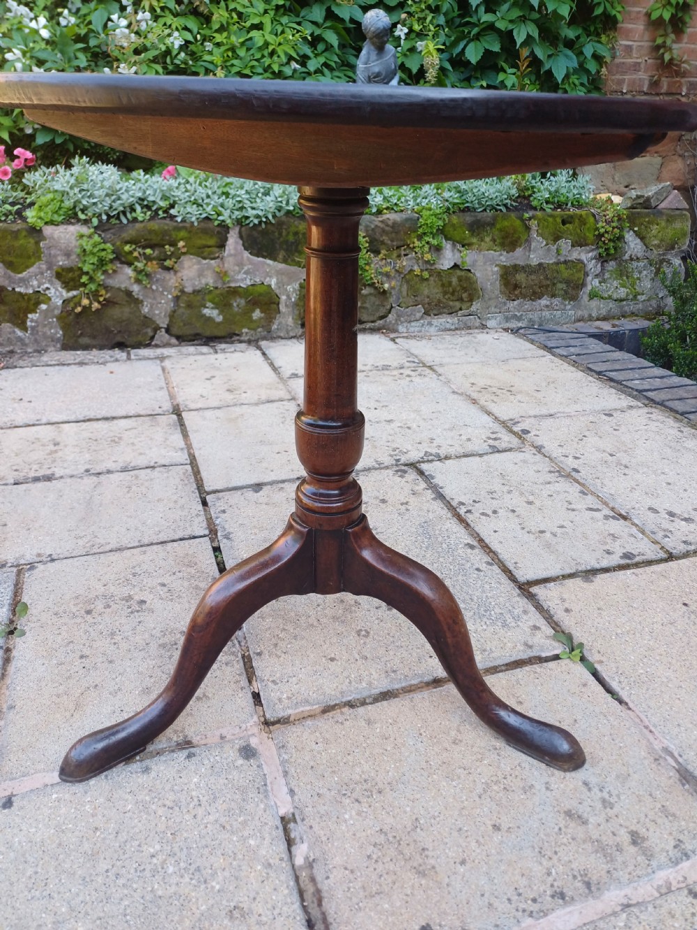 A Georgian mahogany tripod table featuring a circular top, a turned central baluster pedestal, and three splayed cabriole legs. View VII