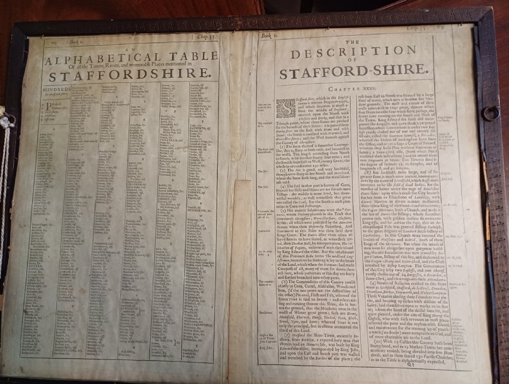 Framed 17th-century hand-coloured engraved map of Staffordshire by John Speed featuring heraldic crests and inset town plans of Stafford and Lichfield. View III