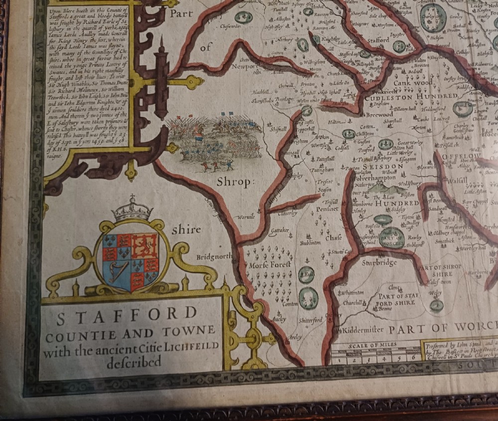 Framed 17th-century hand-coloured engraved map of Staffordshire by John Speed featuring heraldic crests and inset town plans of Stafford and Lichfield. View VII