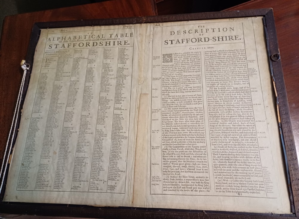 Framed 17th-century hand-coloured engraved map of Staffordshire by John Speed featuring heraldic crests and inset town plans of Stafford and Lichfield. View VIII