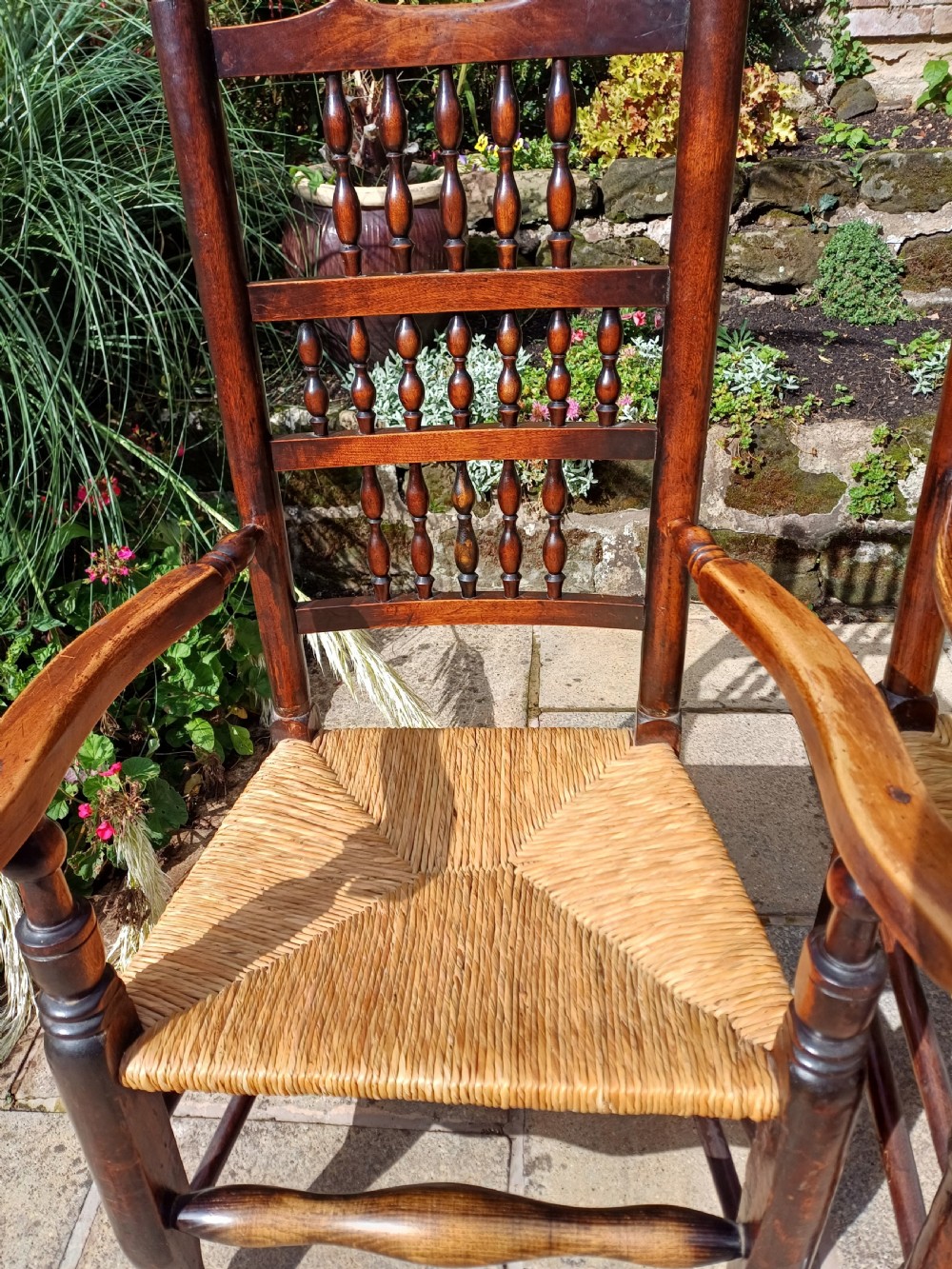 A set of six dark oak spindleback dining chairs featuring hand-woven rush seats and turned wooden legs. View VIII