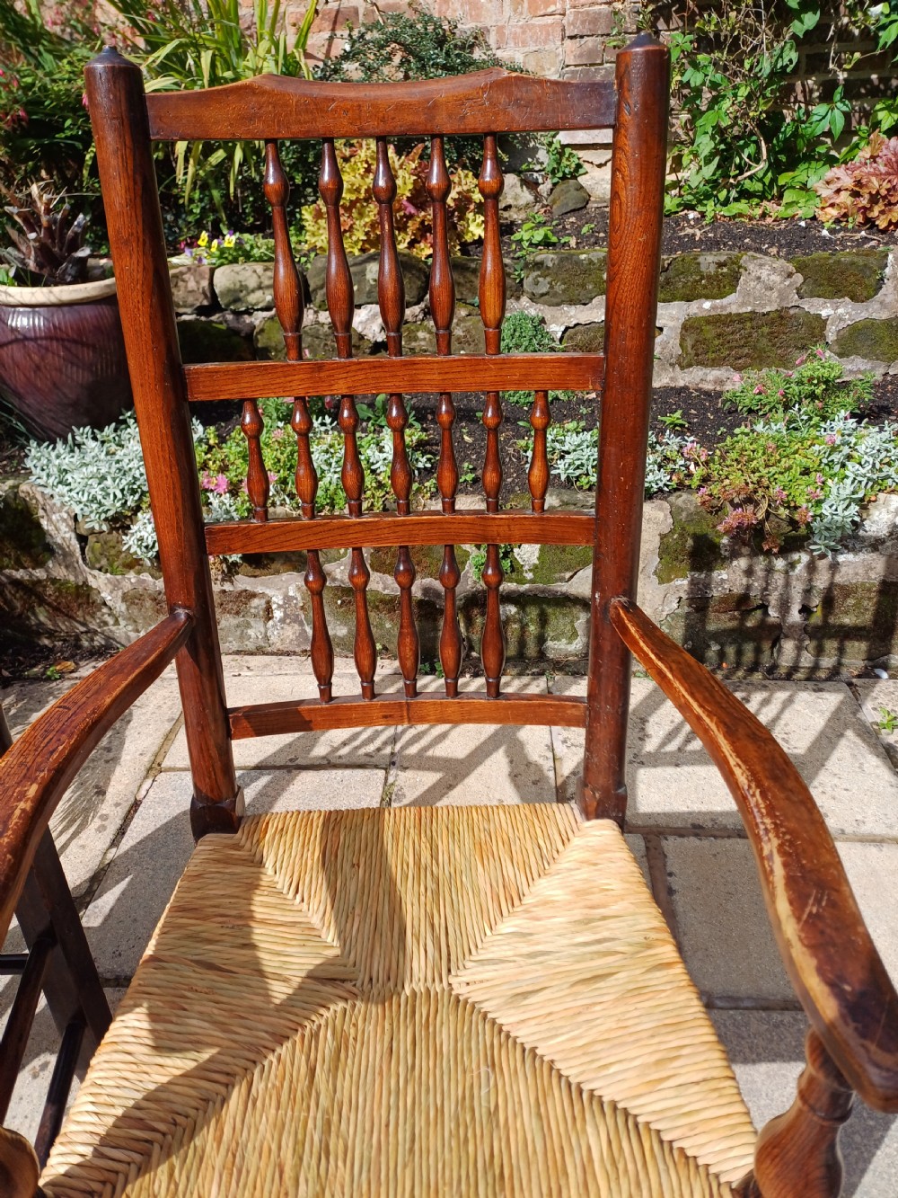 A set of six dark oak spindleback dining chairs featuring hand-woven rush seats and turned wooden legs. View IX