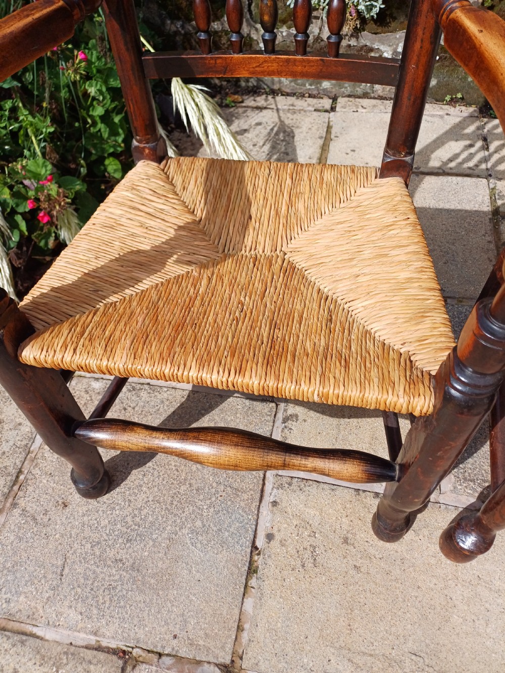 A set of six dark oak spindleback dining chairs featuring hand-woven rush seats and turned wooden legs. View X