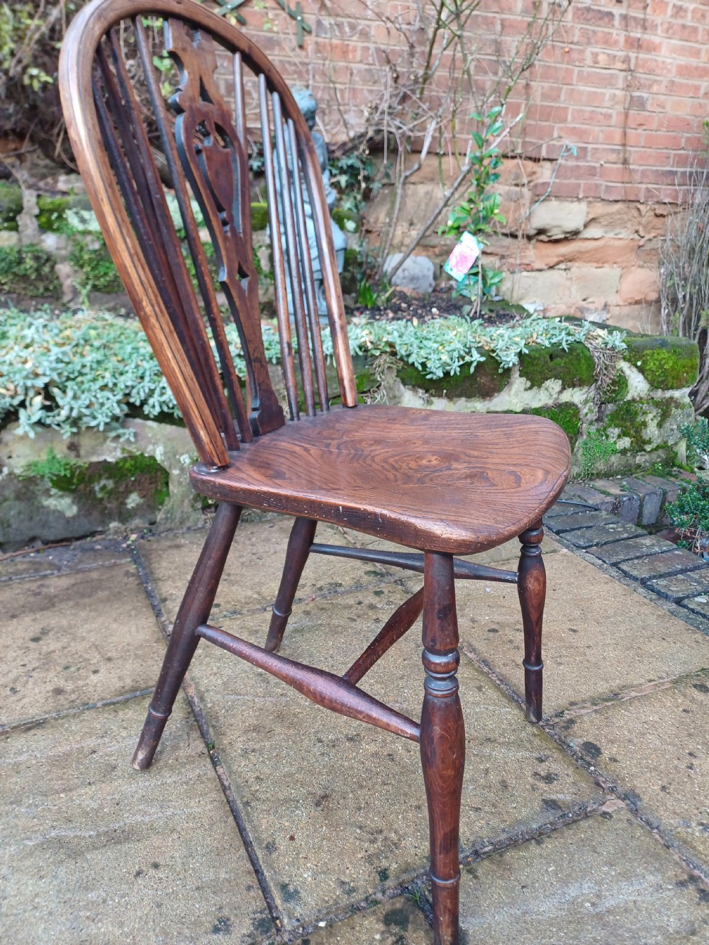 An early nineteenth-century wooden wheelback Windsor chair featuring a contoured elm saddle seat, pierced wheel splat, arched hoop back, and turned legs. View IV