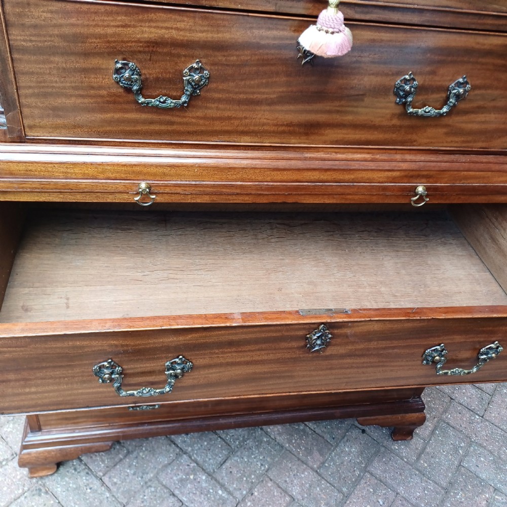 An 18th-century Georgian mahogany tallboy chest on chest featuring a carved frieze, brass handles, and multiple graduated drawers. View XII