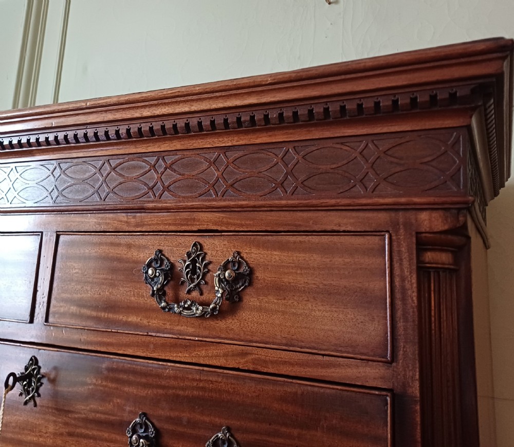 An 18th-century Georgian mahogany tallboy chest on chest featuring a carved frieze, brass handles, and multiple graduated drawers. View XIII