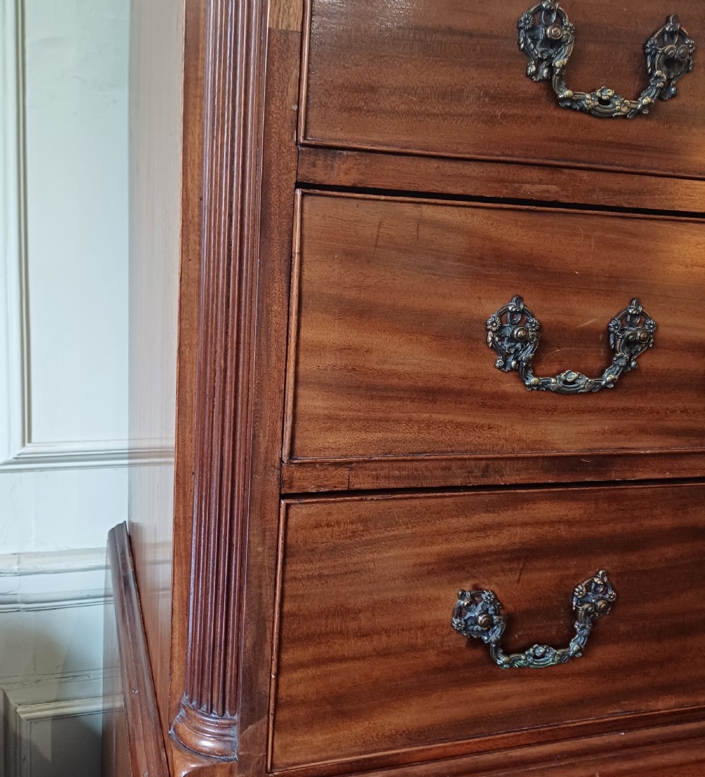 An 18th-century Georgian mahogany tallboy chest on chest featuring a carved frieze, brass handles, and multiple graduated drawers. View XIV