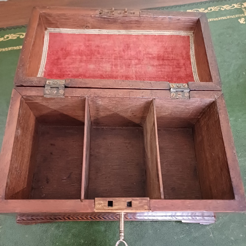 An antique Georgian mahogany tea caddy featuring a domed lid, brass top handle, chevron string inlay, and a diamond bone escutcheon. View VII